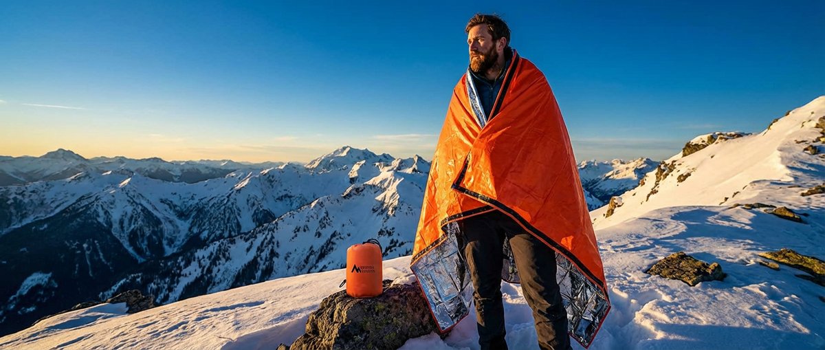 Bright orange Sierra Madre Emergency Sleeping Bag on mountain terrain